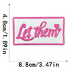Pink embroidered patch with the text Let them on a white background