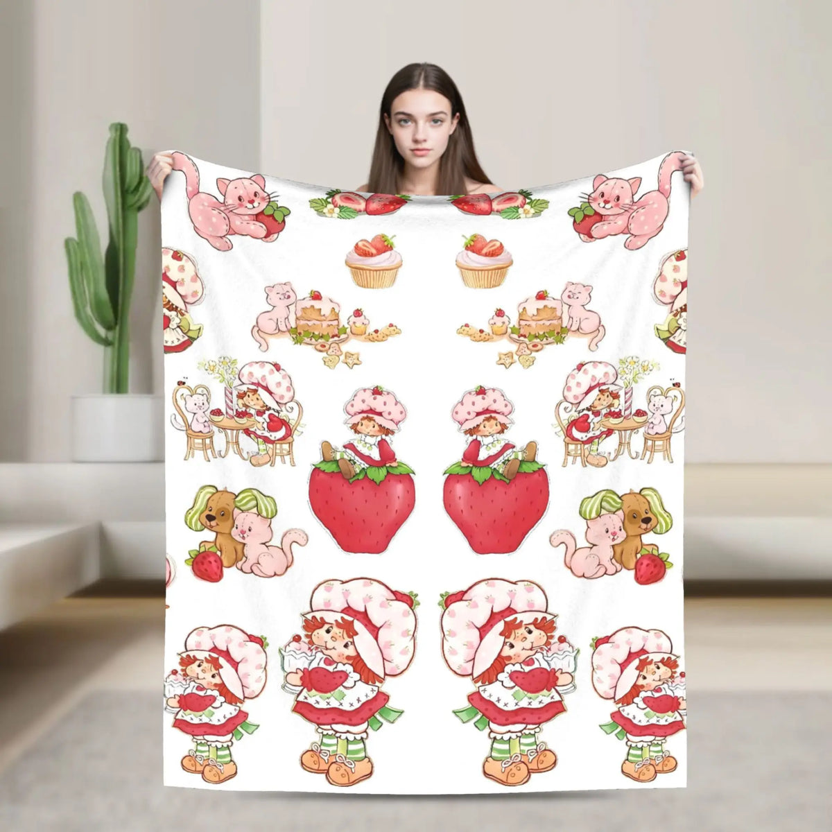 A white throw blanket featuring various strawberry shortcake themed plush animals and characters.