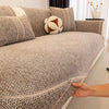 A close-up of a textured gray sofa cushion cover with decorative piping and a small cream-colored accent pillow.