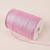 A roll of pink glitter satin ribbon with a white core and a thin trailing end.