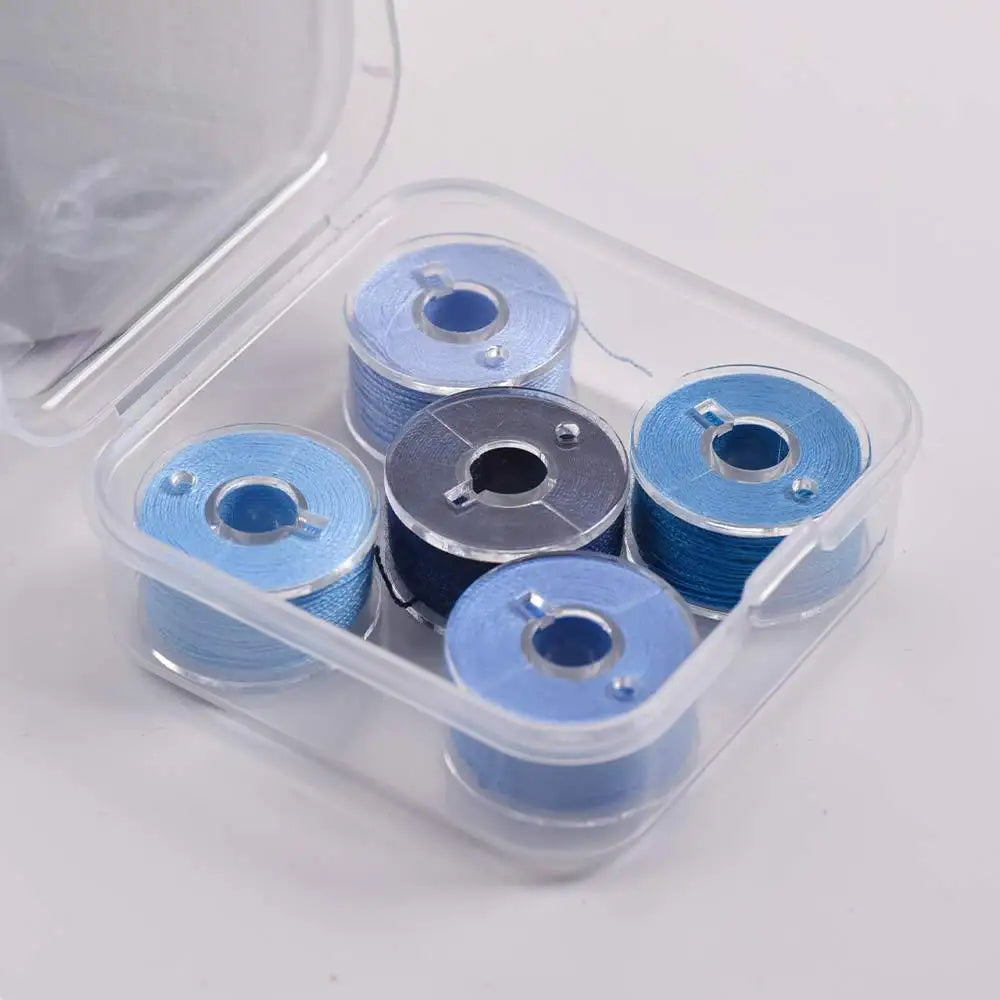 Clear plastic container holding several spools of prewound sewing machine bobbin threads