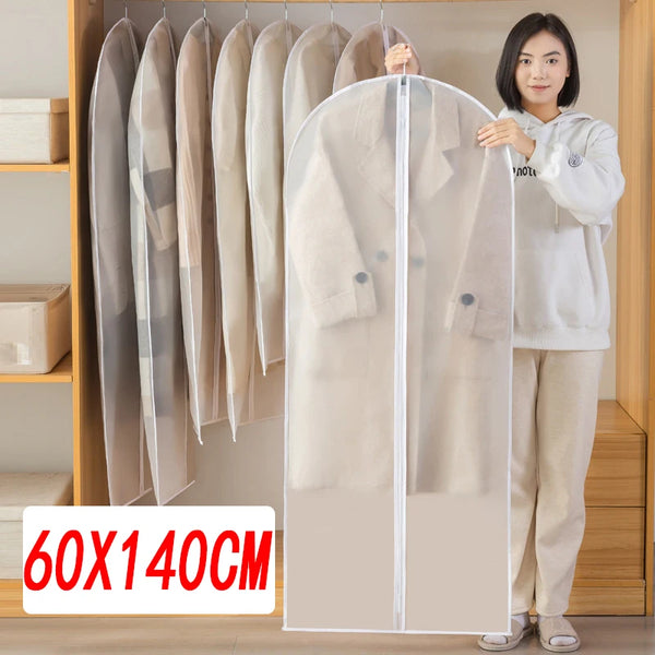 A woman is standing in front of a transparent zippered clothes storage bag with hangers displaying beige coats.
