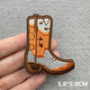 An embroidered iron-on patch shaped like a cowboy boot in brown and gray thread.