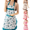 A woman models a floral print kitchen apron with pockets and an adjustable belt in white, green, and pink tones.