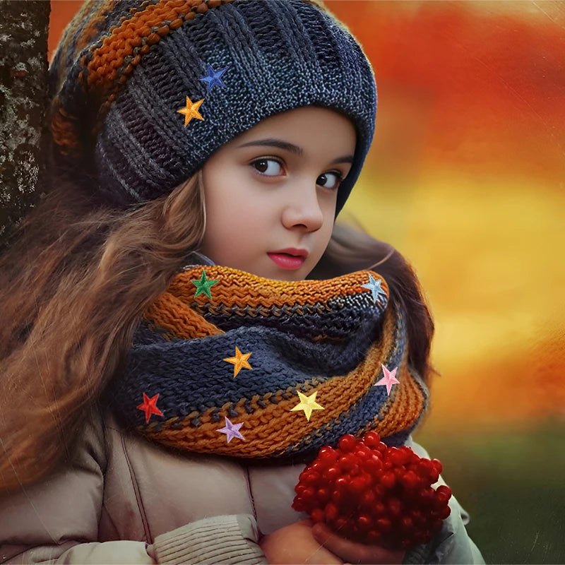A young girl wearing a knitted hat and scarf decorated with five-pointed star embroidery patches.