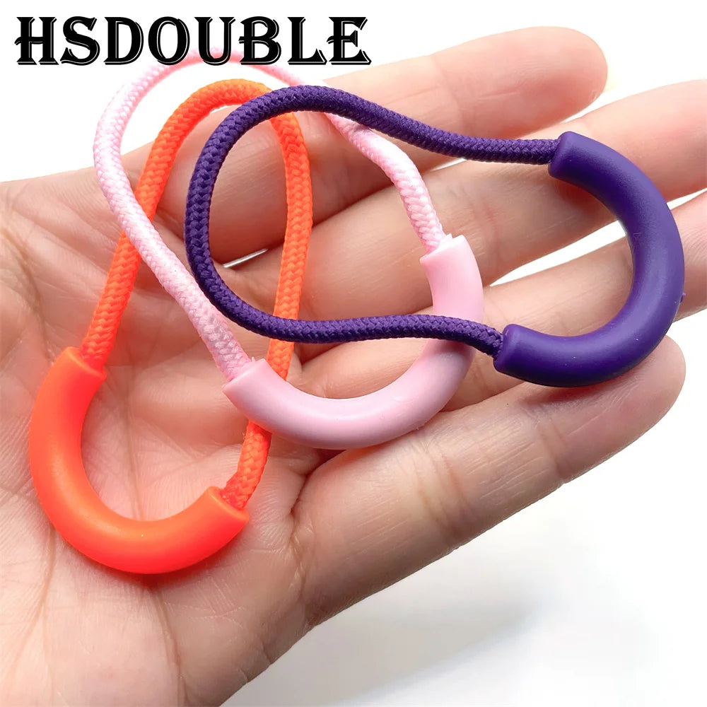 A hand holds several U-shaped zipper pull straps in mixed colors including orange, pink, and purple.