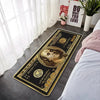 A rectangular gold and black decorative floor mat featuring a portrait of a man on US currency.
