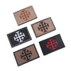 A collection of embroidered patches featuring a cross design in brown, black, and red thread.