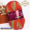 A ball of gradient dyed orange and green wool yarn with a purple label and a decorative gold stamp.