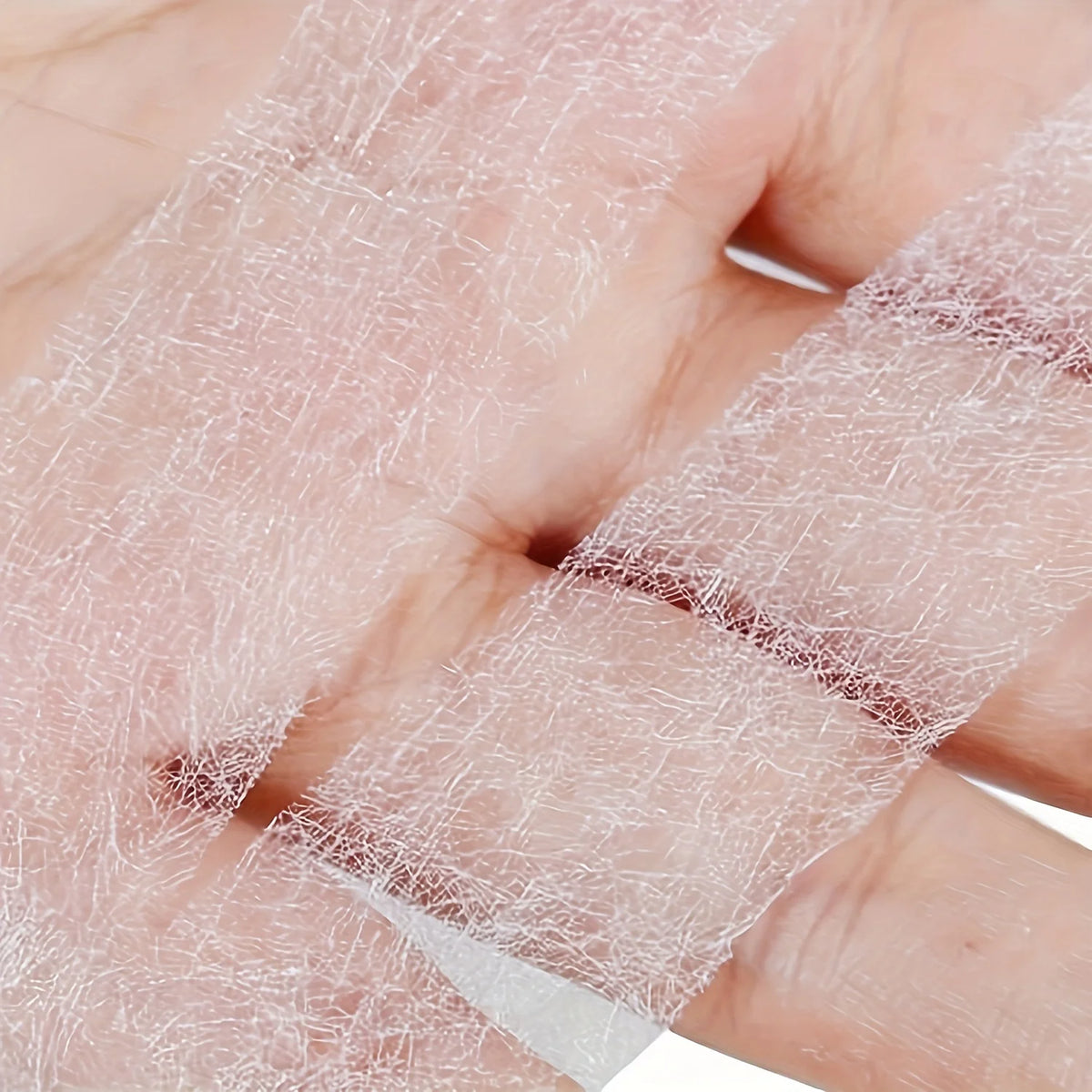 Clear fusible hem tape applied to a finger, showing the transparent adhesive material.