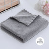 A stack of ten gray, fluffy velvet cleaning face towels is displayed on a white surface.