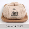A ball of beige 100% organic cotton yarn labeled QJH with environmental protection dyeing details.