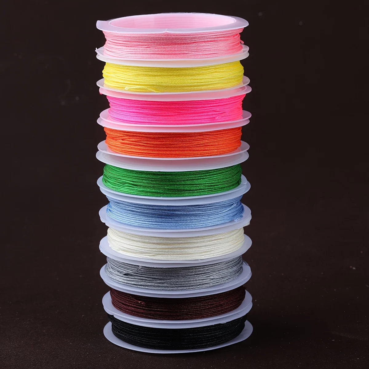A stack of colorful nylon cord sets in various shades of pink, yellow, orange, green, blue, and gray.