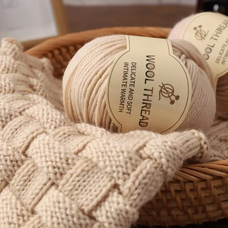 A ball of beige wool thread labeled Delicate and Soft, resting on a woven basket.