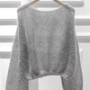 A gray knitted sweater made from premium mohair yarn displayed on a hanger.