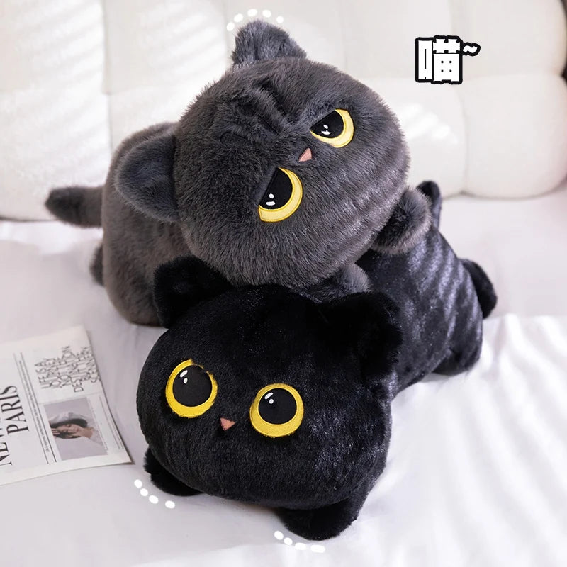 A cute black cat plush toy with yellow eyes is resting on a white surface.