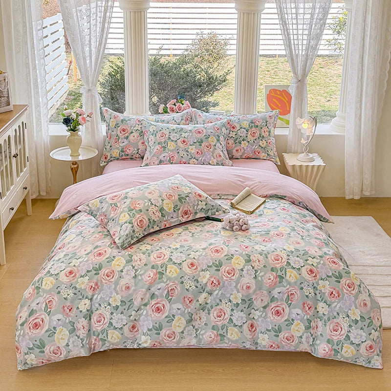 A pink floral duvet cover and pillow set displayed on a bed with white curtains and wooden furniture.