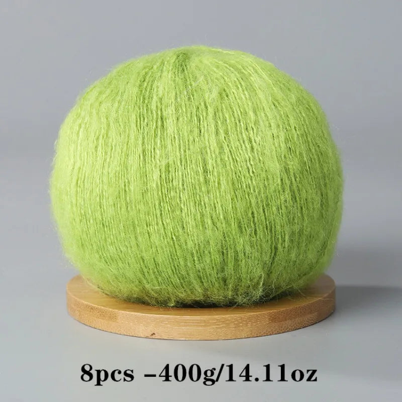 A ball of bright lime green mohair yarn resting on a wooden base.