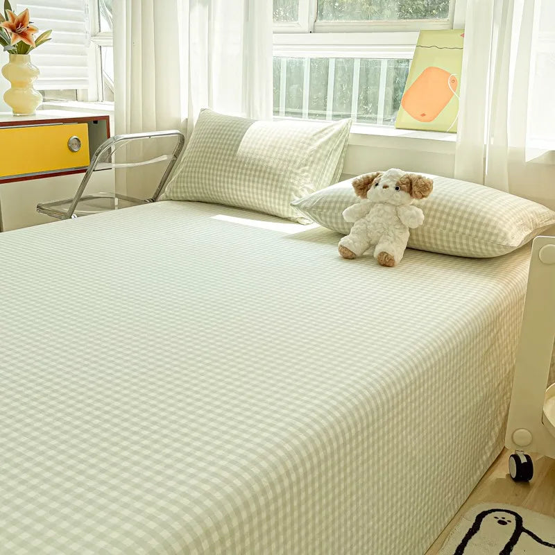 A bed with white and green striped bedding, a stuffed bear pillow, and a yellow accent on the window sill.