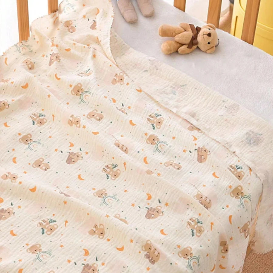 A soft double-layer cotton baby swaddle blanket with a light beige pattern featuring small animal figures and orange accents.