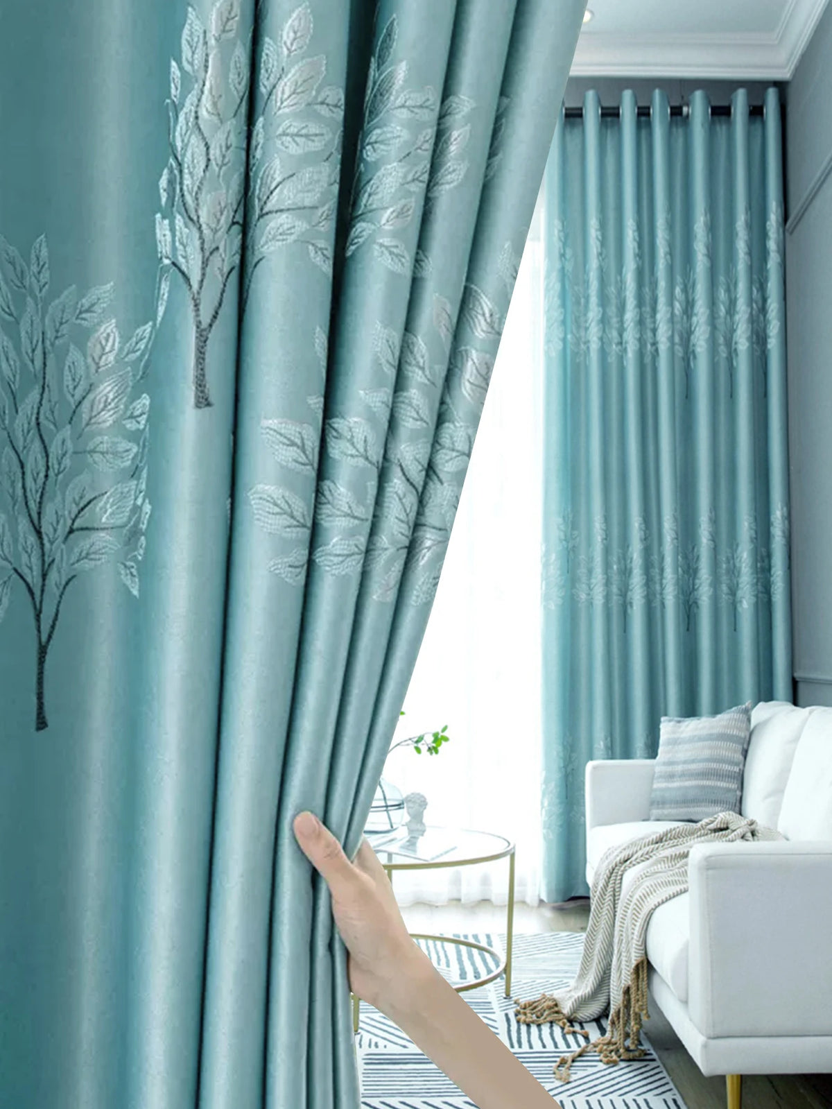 Light blue curtains featuring a white tree pattern, drawn open in a bright room.