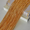 Golden beaded door string curtains laid out next to a book.