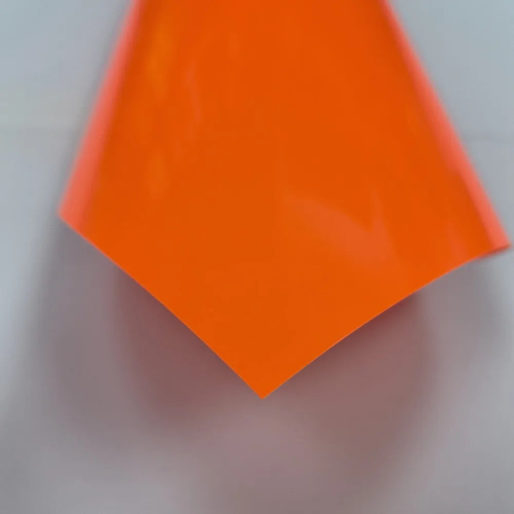 A bright orange, triangular sheet of 3D puff heat transfer vinyl for apparel.