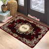 A luxury floral area rug in deep red and gold patterns placed on a light wood floor.