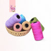 A collection of hand knitting and crochet cord in various colors including purple blue pink and green spools.