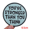 A light blue embroidered patch with the text You're stronger than you think on a black background.