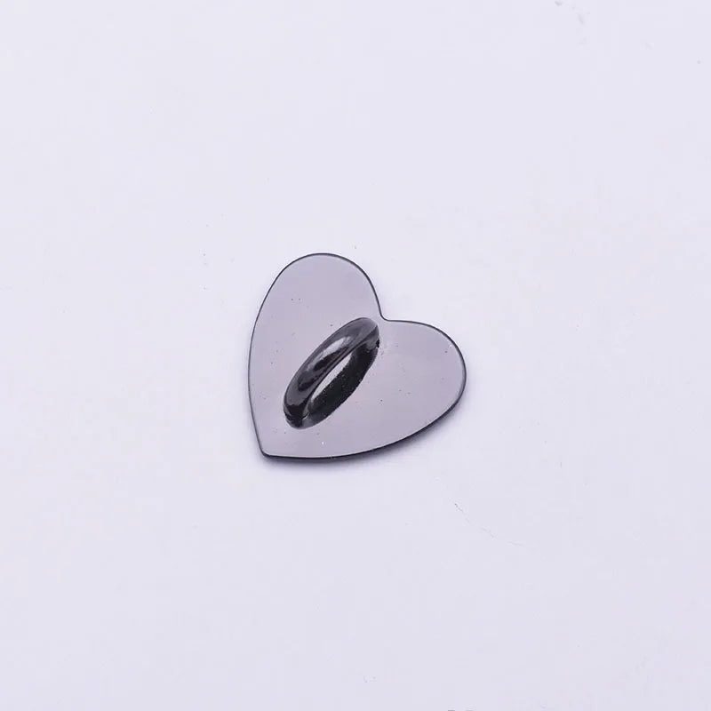 A small, polished silver heart-shaped metal charm used as a phone connector.