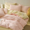 A set of pink and pale yellow polyester bedding including a duvet cover and pillowcases.