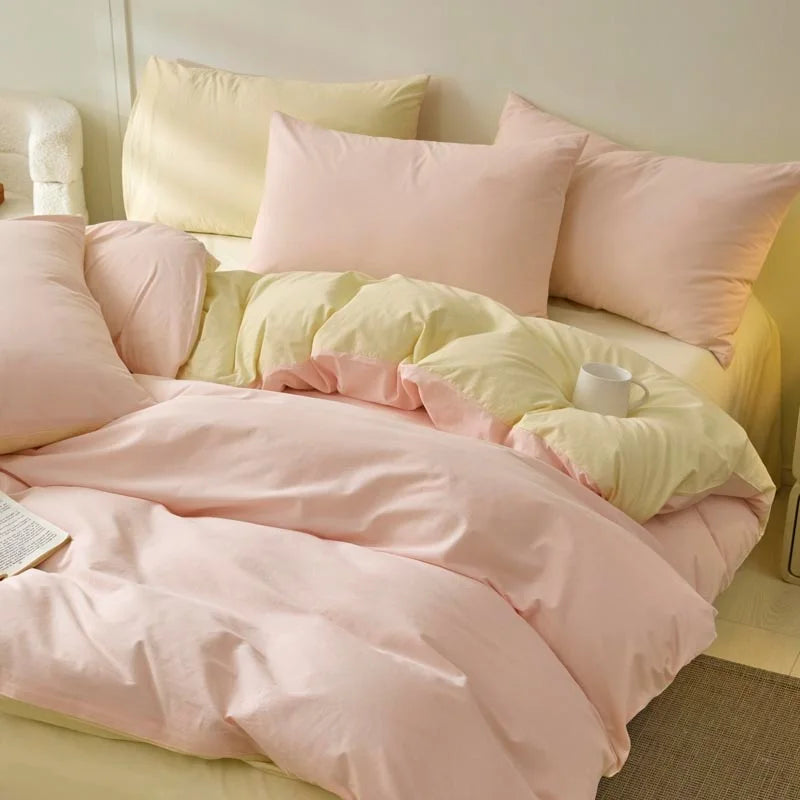A set of pink and pale yellow polyester bedding including a duvet cover and pillowcases.