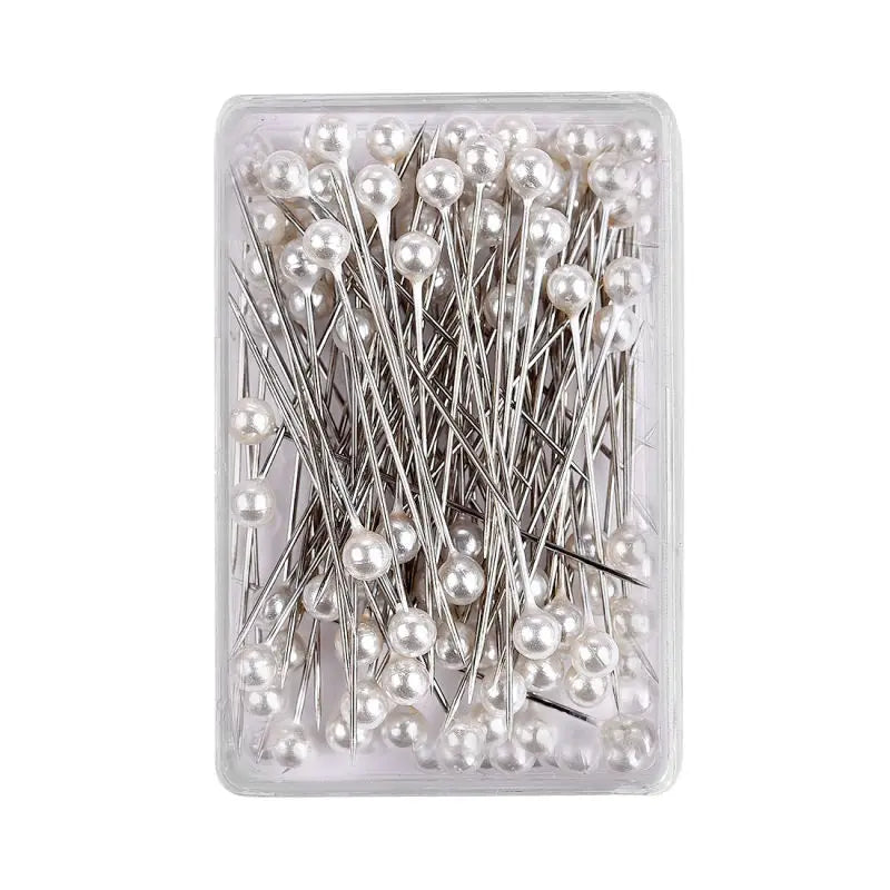 A clear plastic container filled with 100 pearl head sewing pins for dressmaking and DIY projects.
