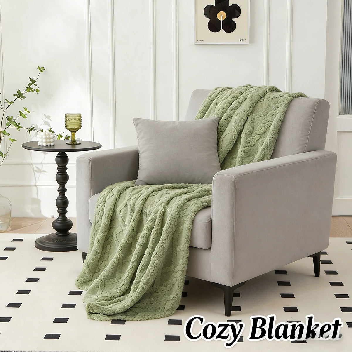 A light gray armchair draped with a green plush blanket on a white rug.