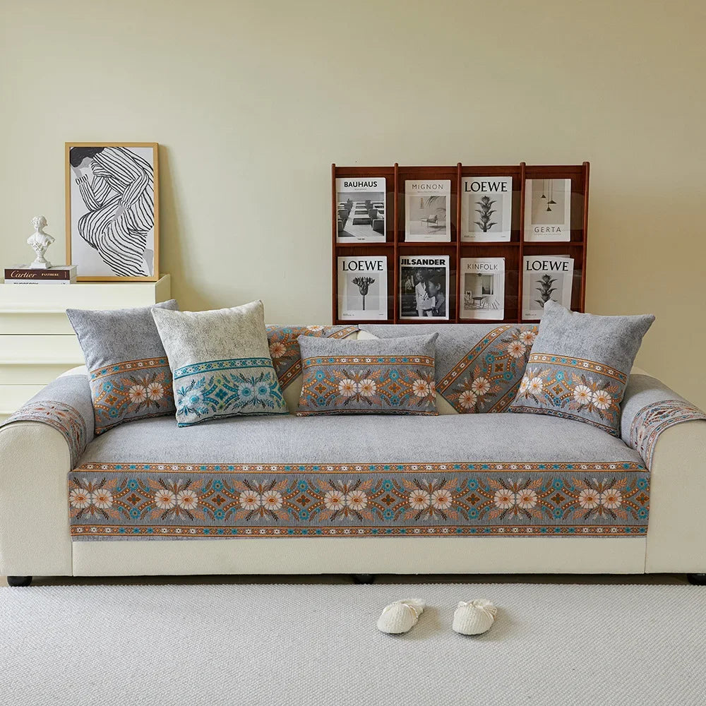 A beige sofa covered in patterned fabric, featuring a row of framed books on the wall.