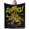 A person holds up a black blanket featuring a graphic of a dog character and the text ZOINKS!