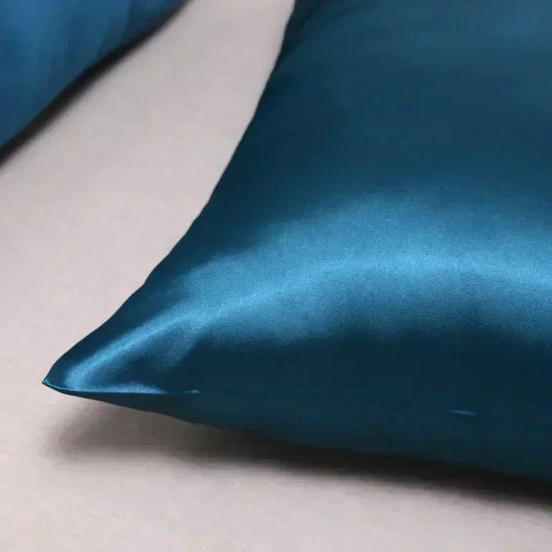 A close-up of a deep teal luxury mulberry silk pillow cover fabric.