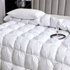 White quilted duvet with a fluffy pillow on a bed