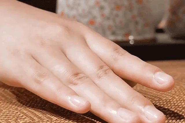 A hand rests on a natural bamboo cooling mat surface.