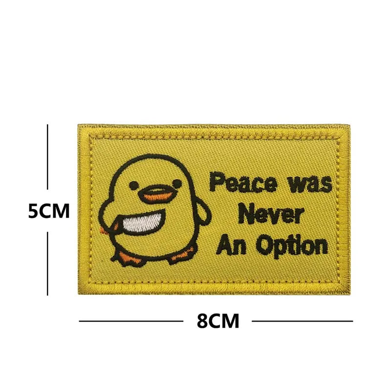 A yellow embroidery patch featuring a cartoon duck and the text Peace was Never An Option.