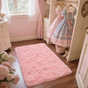A fluffy pink bedroom carpet with a non-slip backing is displayed on a wooden floor.