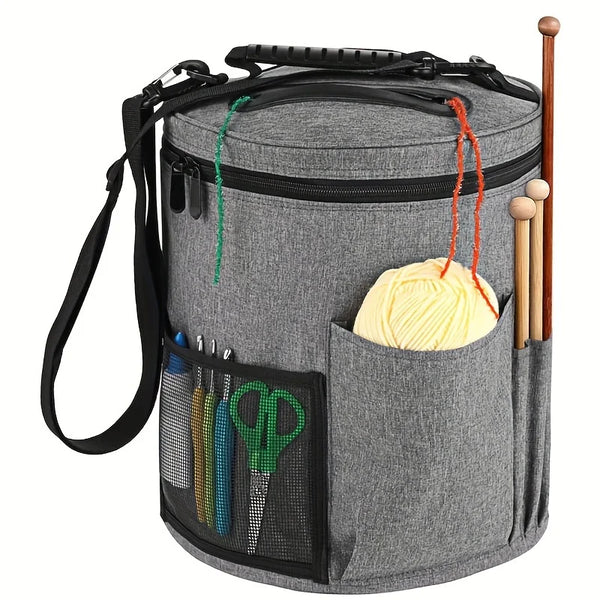 A gray crochet tote bag with a zipper, featuring a yarn storage pouch and a pocket for tools.