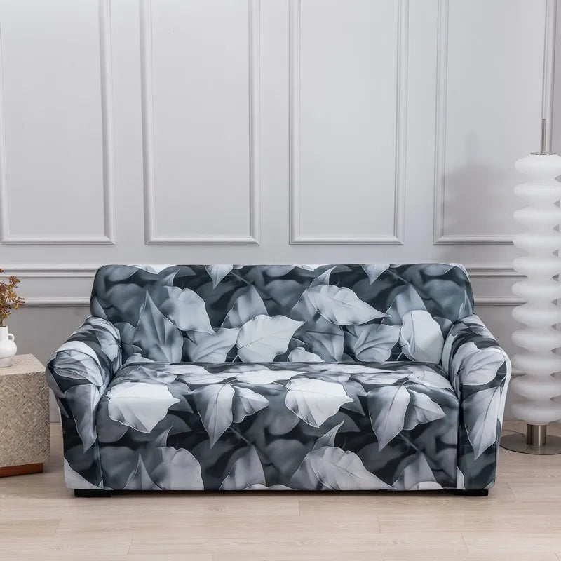 A dark gray and white floral patterned stretch fabric sofa cover displayed indoors.