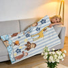 A striped blanket featuring illustrations of C-Curious George characters, including him riding a giraffe and other figures.