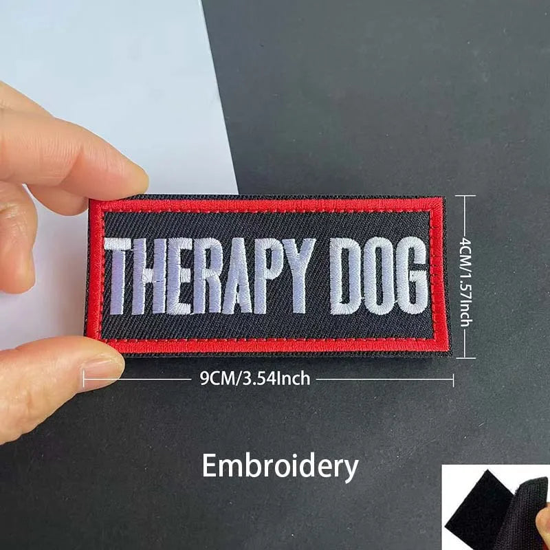 A black and red embroidered patch with the text Therapy Dog on a dark background.