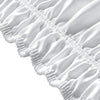 Close-up of a white wrap around elastic bed skirt with gathered fabric details.