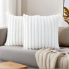 A white, vertically ribbed decorative pillowcase is displayed on a gray sofa.