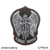 An embroidered patch featuring a winged figure with a sword and the text St Michael Protectus on a dark background.