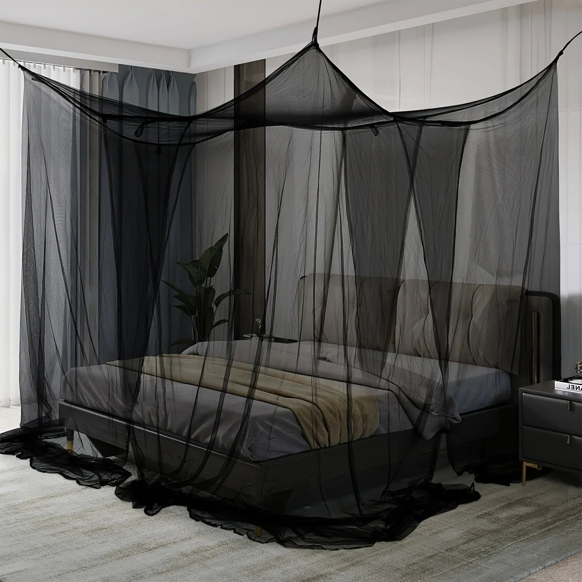 A floor-to-ceiling black mosquito net curtain draped over a bed in a room.